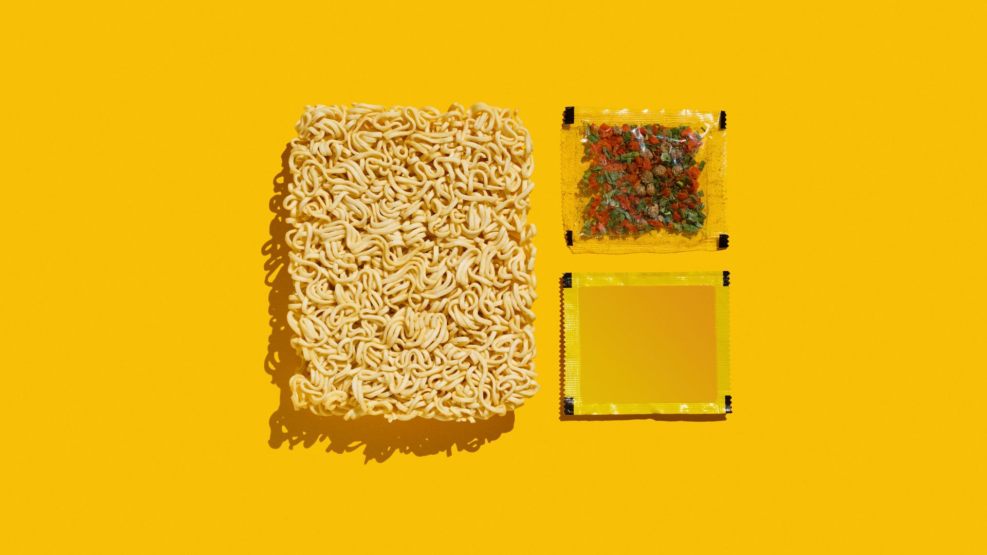 A Mie Noodles noodle cake, spices in a small transparent bag
